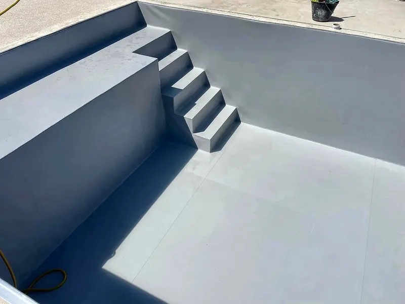 PVC armé – PVC armé gris clair : escalier et banquette soudés sur place.