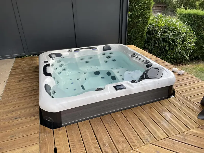 Spa sur terrasse bois – Installation d’un spa en extérieur, sur une terrasse en bois.