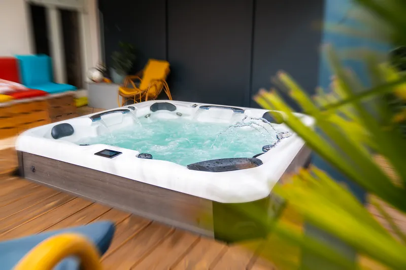 Spa sur terrasse bois – Spa posé sur une terrasse en bois, cascades en marche.
