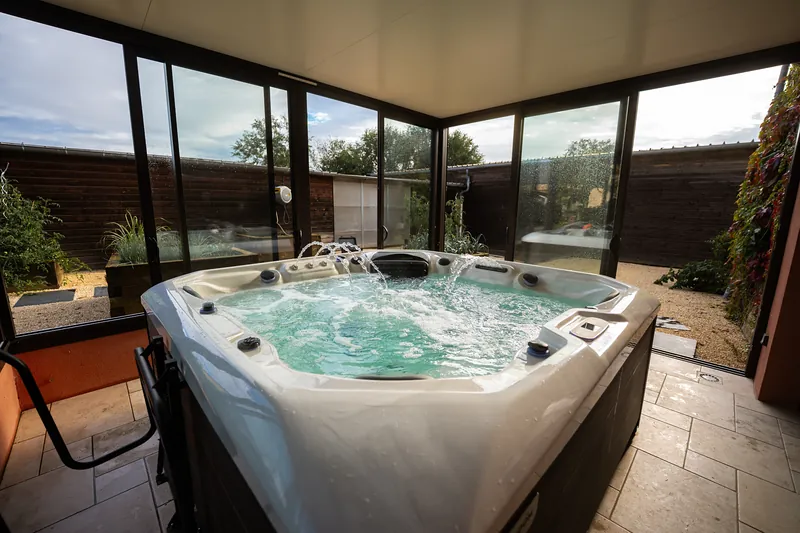 Spa sous véranda – Spa installé dans une véranda vitrée, fontaines en marche.
